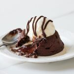 a white plate topped with a piece of cake and ice cream