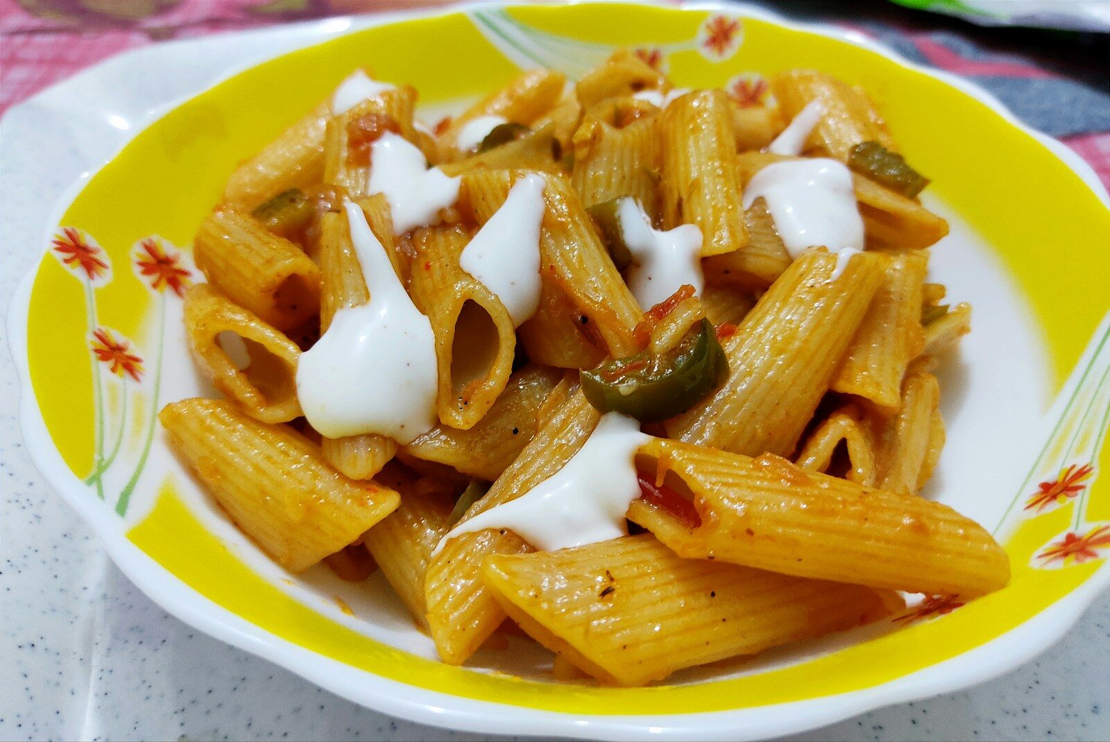 a yellow and white plate topped with pasta and sauce