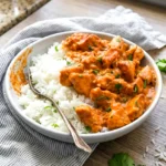 Coconut chicken rice bowl served over rice with creamy sauce and cilantro