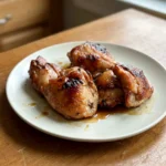 Baked honey soy chicken thighs glazed and browned on a simple plate