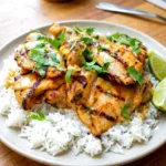 Thai boneless chicken thighs served on a plate with a light coconut curry sauce and cilantro