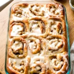 Apple cinnamon rolls with caramel icing in a 9x13 glass baking dish