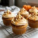 Pumpkin cupcakes with caramel cream cheese frosting on a wire rack