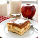 Slice of no bake caramel apple cake on a white plate with caramel drizzle