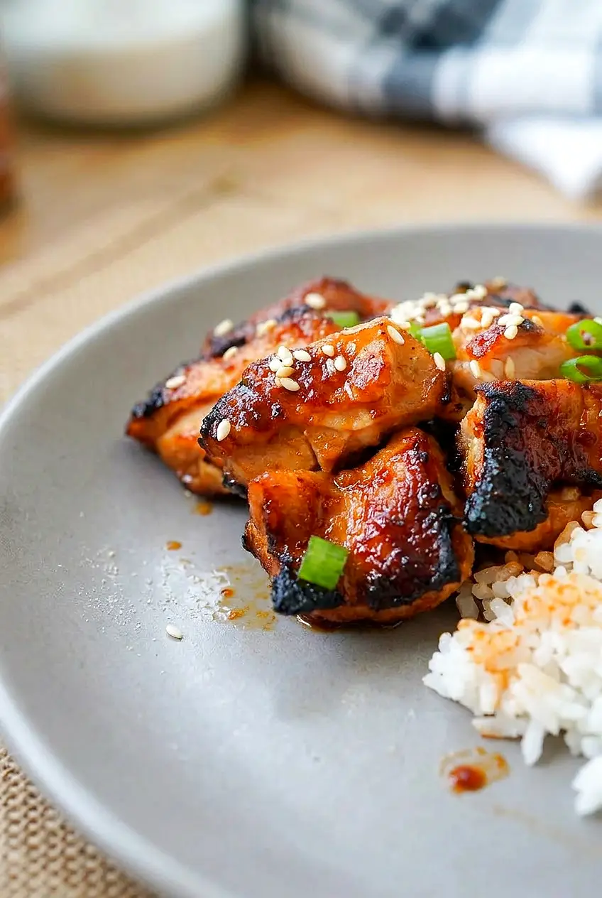 Close-up of spicy Korean chicken showing browned edges and glossy gochujang glaze