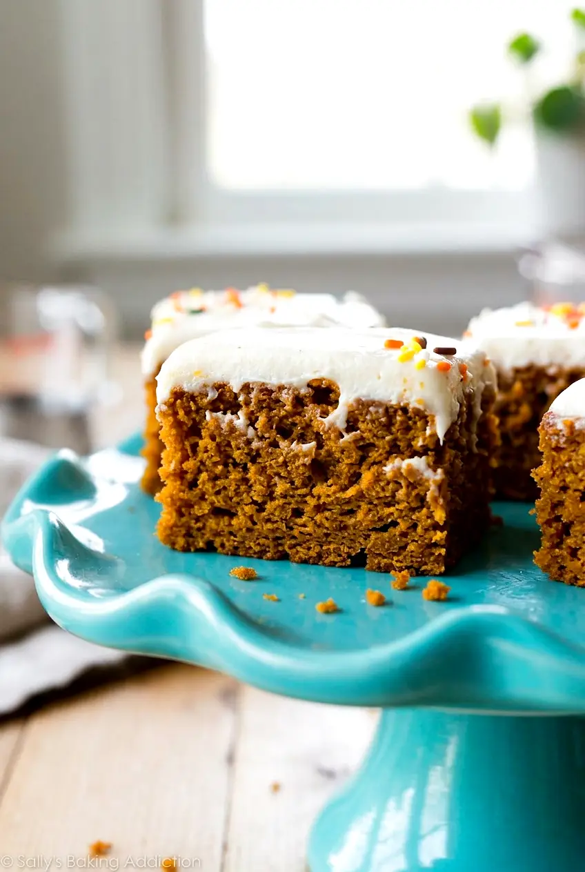 Close-up of pumpkin bars showing the soft crumb and cream cheese frosting layers