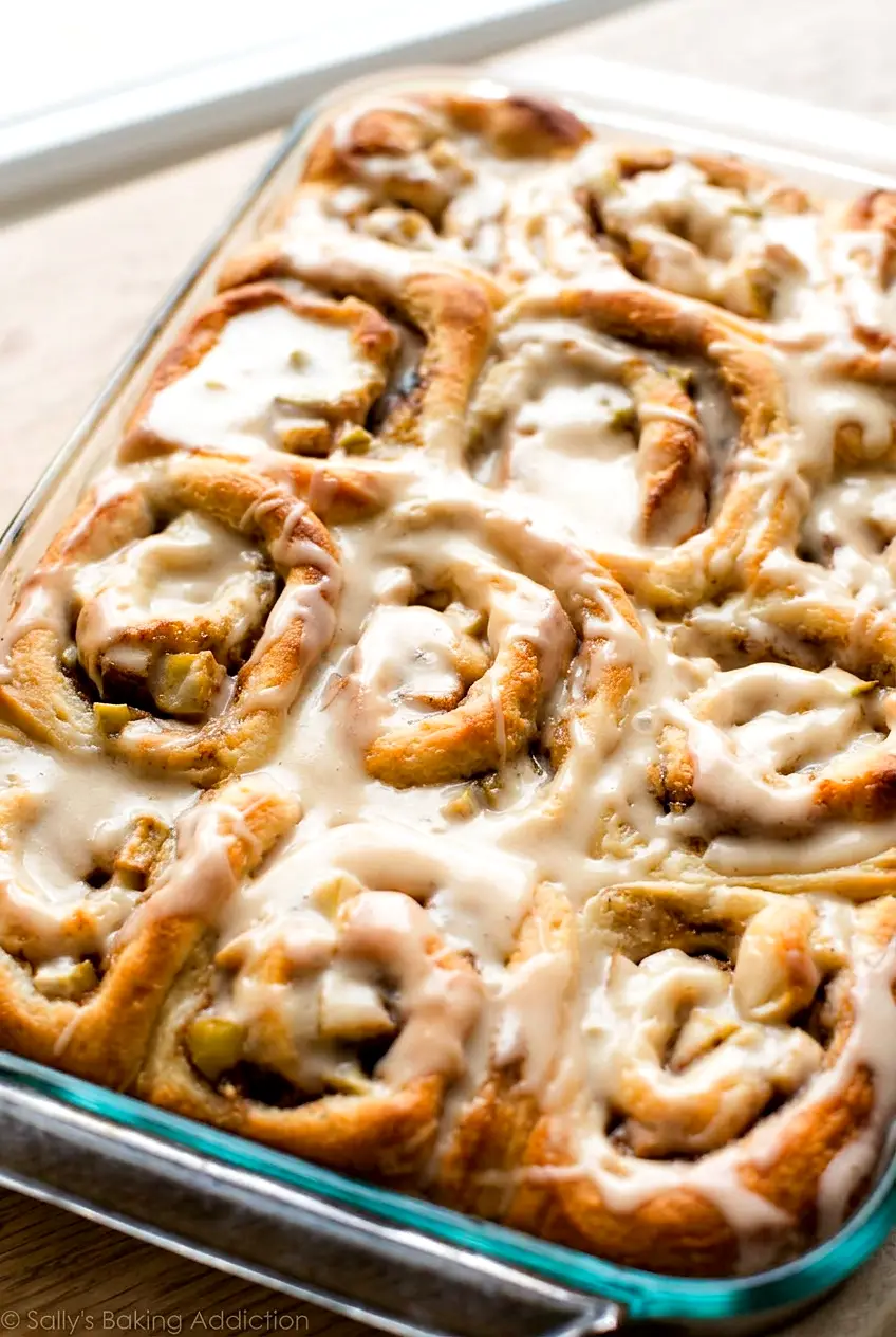 Close-up of apple cinnamon rolls with caramel icing showing the soft swirls and baked edges