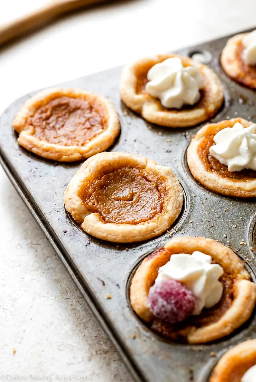 Close view of mini pumpkin pies showing the smooth pumpkin filling and browned crust edges