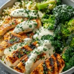 Grilled chicken and broccoli rice bowl with creamy garlic sauce and parsley