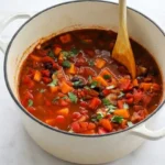 Black bean chili with sweet potato cubes and cilantro in a light Dutch oven