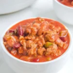 Full white bowl of Wendy’s copycat chili with beef, kidney beans, pinto beans, and red-orange sauce
