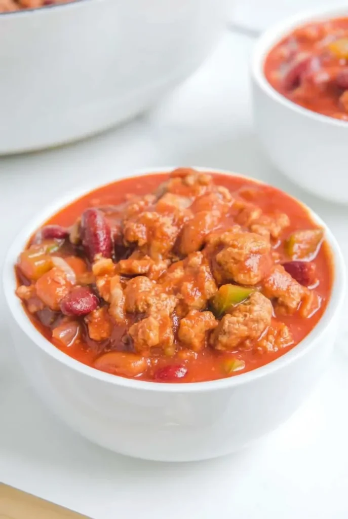 Full white bowl of Wendy’s copycat chili with beef, kidney beans, pinto beans, and red-orange sauce