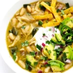 Poblano chicken chili with white beans, shredded chicken, tortilla strips, sour cream, avocado, and fresh garnishes