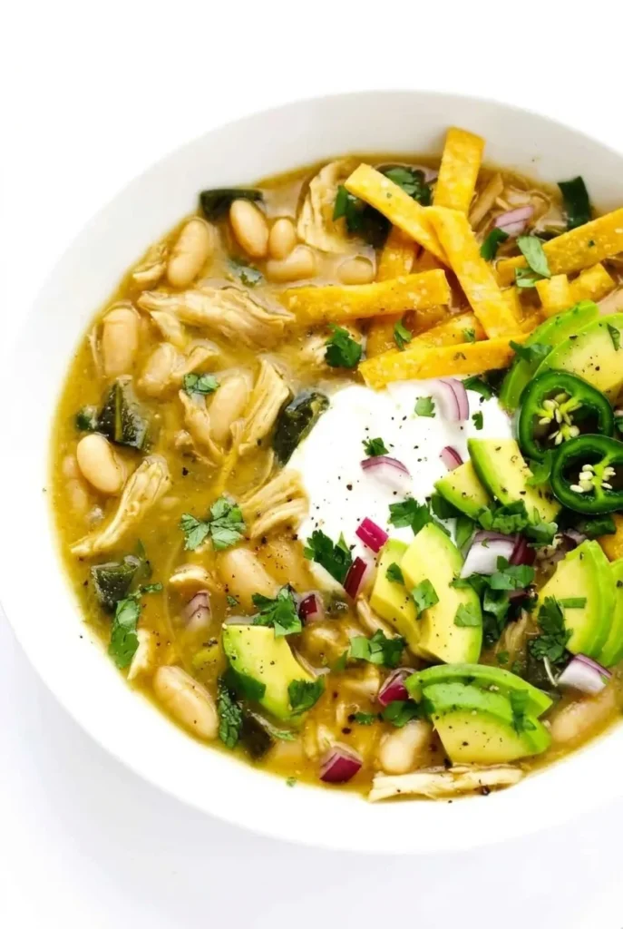 Poblano chicken chili with white beans, shredded chicken, tortilla strips, sour cream, avocado, and fresh garnishes