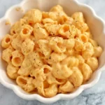 Creamy stovetop mac and cheese with black pepper in a white scalloped bowl