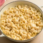 Cream-colored pot of Panera-style mac and cheese with hollow pasta coated in pale cheddar sauce