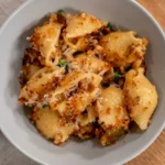 Bowl of high-protein shell mac and cheese with creamy golden sauce, toasted crumbs, and Parmesan