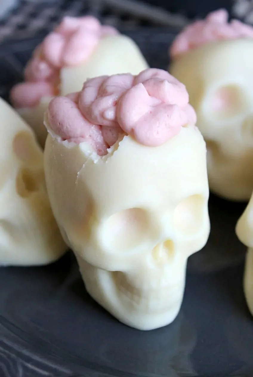 Close view of a white chocolate skull showing the jagged crown edge and thick pale-pink cheesecake mousse brain folds.