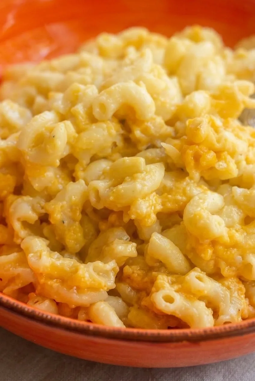 Close view of distinct elbow macaroni coated in uneven golden four-cheese sauce
