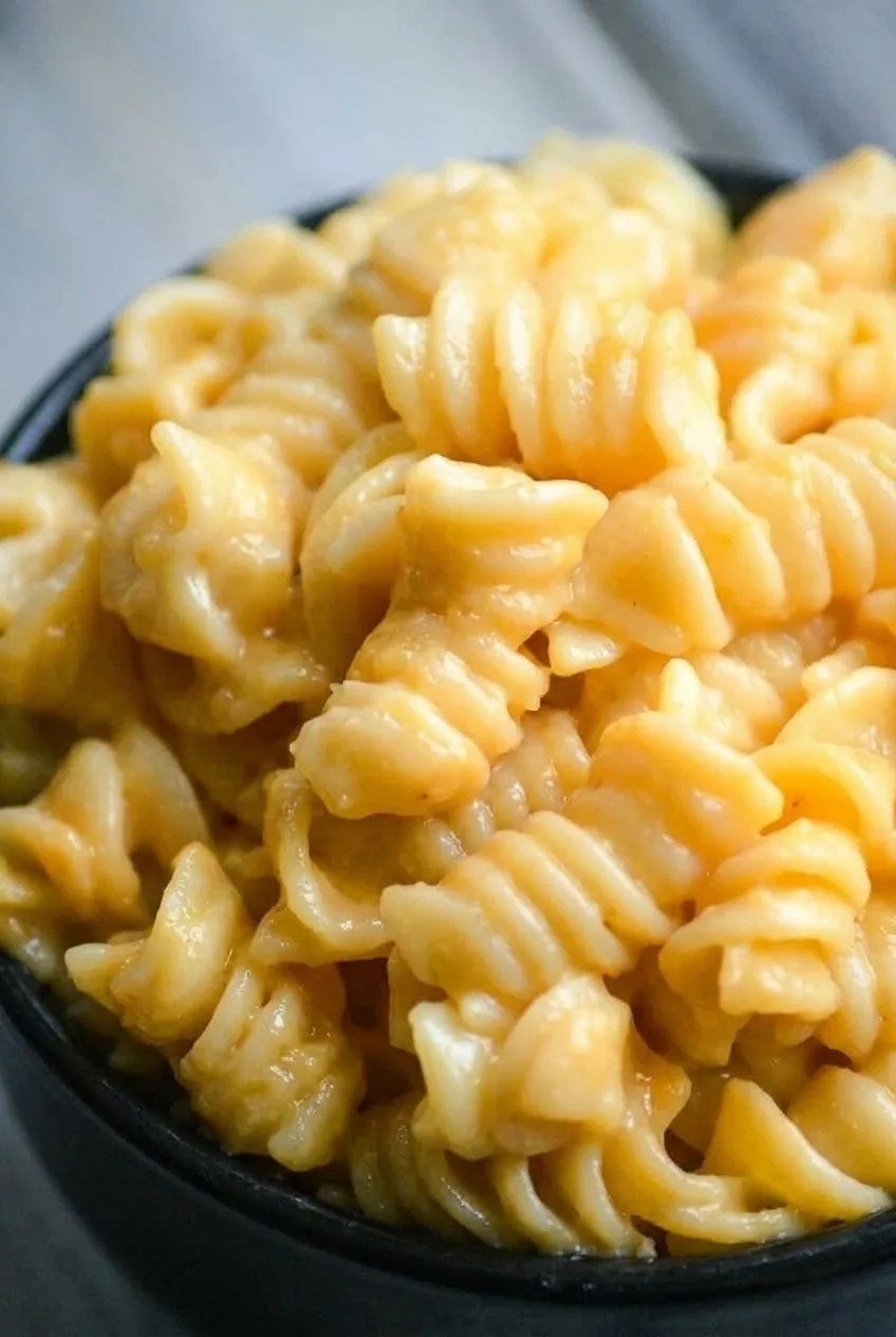Close view of defined rotini spirals coated in creamy cheese sauce