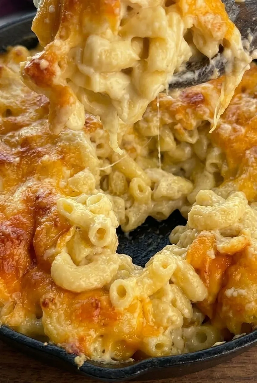 Close view of moist elbow macaroni beneath the browned cheese crust of skillet mac and cheese