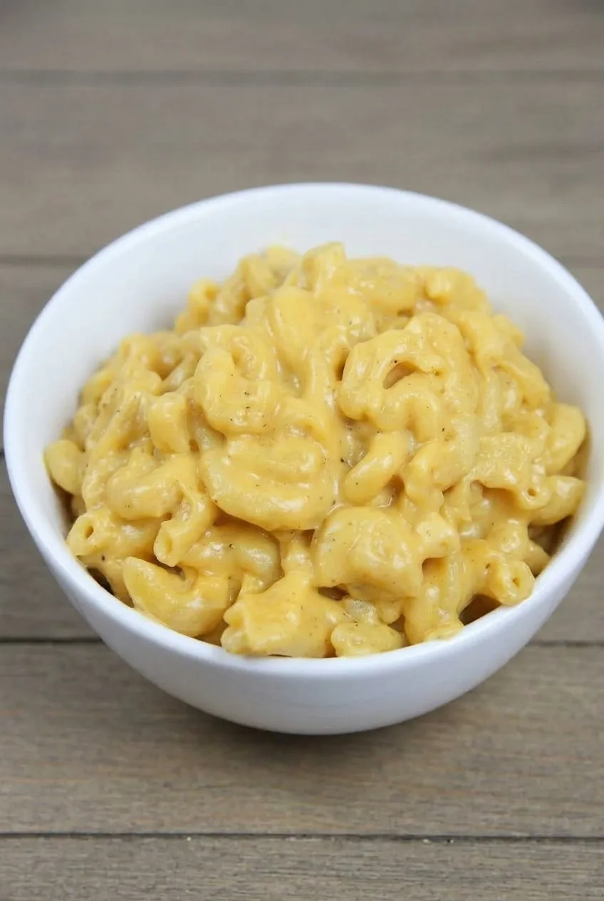 Complete white bowl of Crockpot mac and cheese on a neutral tabletop