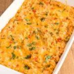 Chicken fajita casserole with rice, peppers, melted cheese, and cilantro in a white baking dish