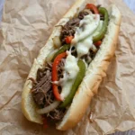 Crockpot Philly cheesesteak with shredded beef, peppers, and melted provolone in a soft hoagie roll