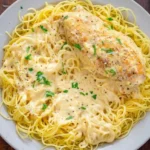 Crockpot Angel Chicken breast in creamy sauce over angel hair, topped with parsley and black pepper
