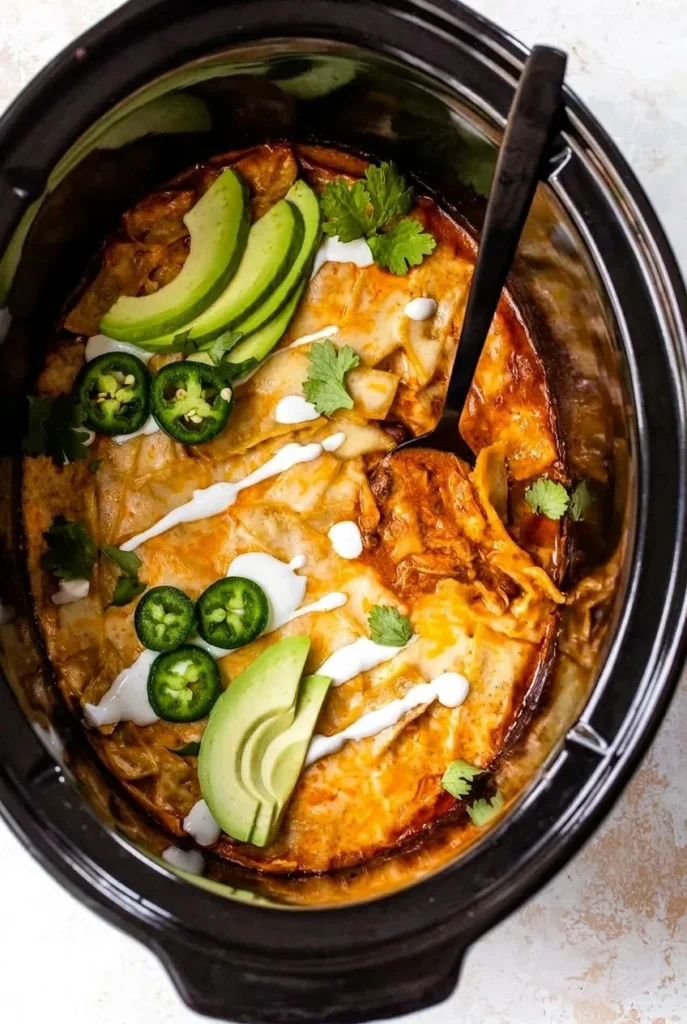 Layered slow cooker chicken enchiladas with avocado, jalapeño, cilantro and sour cream