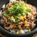 Crockpot Santa Fe chicken over white rice with black beans, corn, melted cheddar, scallions, and cilantro
