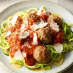 Baked turkey meatballs over zucchini and yellow squash strands with marinara and shaved Parmesan
