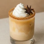Pumpkin Spice White Russian in a rimmed rocks glass with cream swirls, whipped cream and star anise