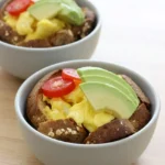 Egg and avocado snack cup with scrambled eggs and tomato in a browned whole-wheat toast cup