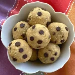 Chickpea cookie dough bites with chocolate chips nestled in a white scalloped bowl