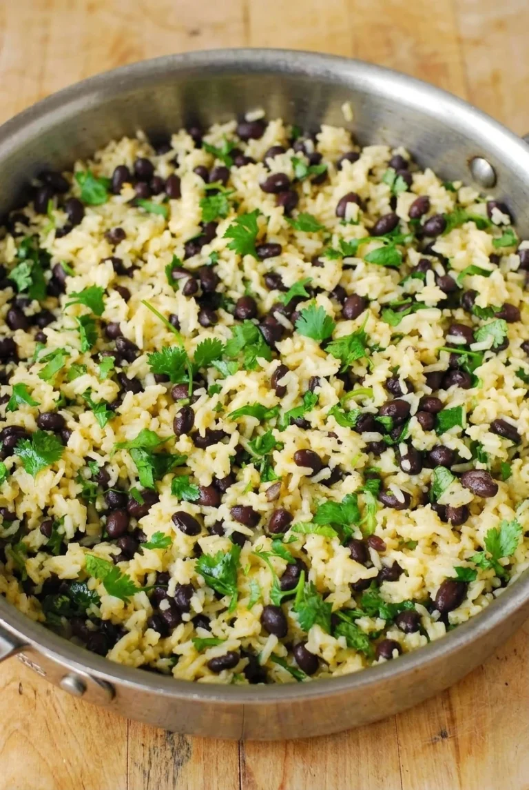 Black Bean and Rice Bowls with Cilantro Lime Sauce Black bean and rice mixture with fresh cilantro in a stainless-steel pan