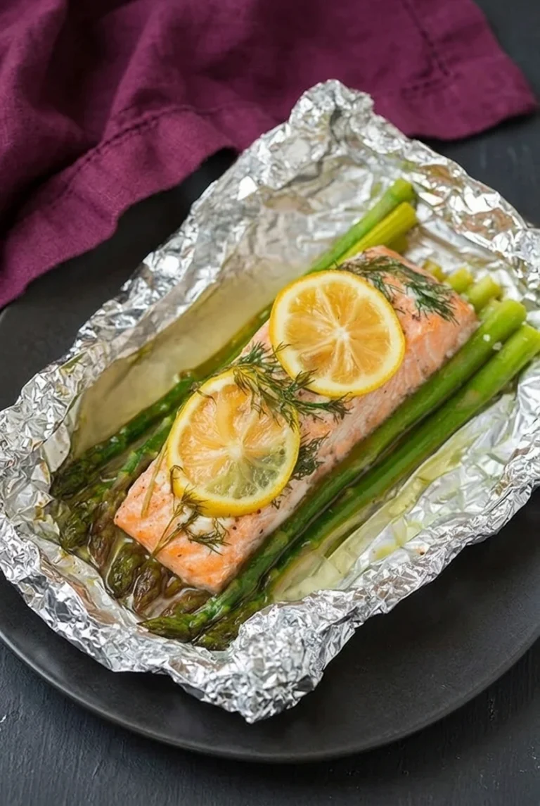 Baked Salmon with Lemon and Asparagus Foil Packets Baked salmon with asparagus, lemon rounds, and dill in an opened, crinkled foil packet