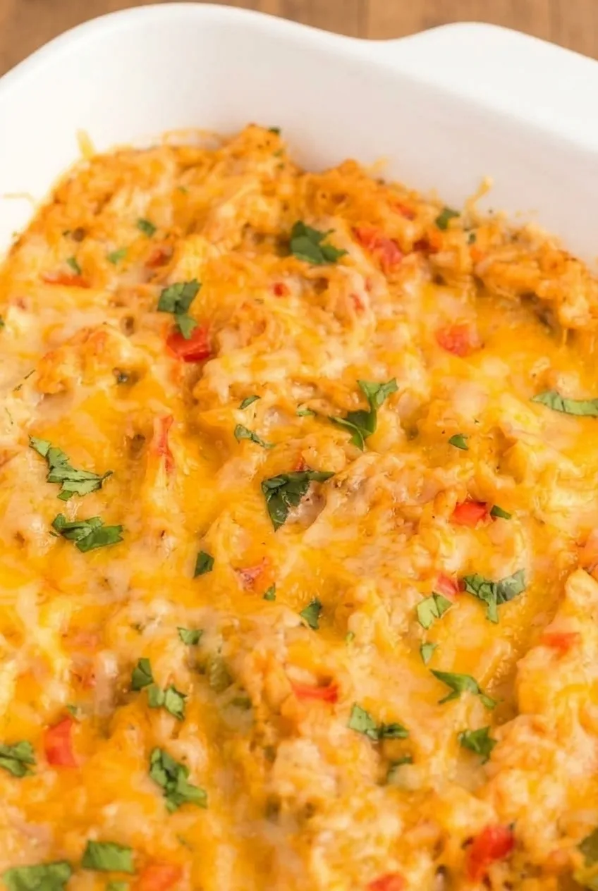 Close view of melted cheese over the casserole’s shredded chicken, rice, and diced peppers