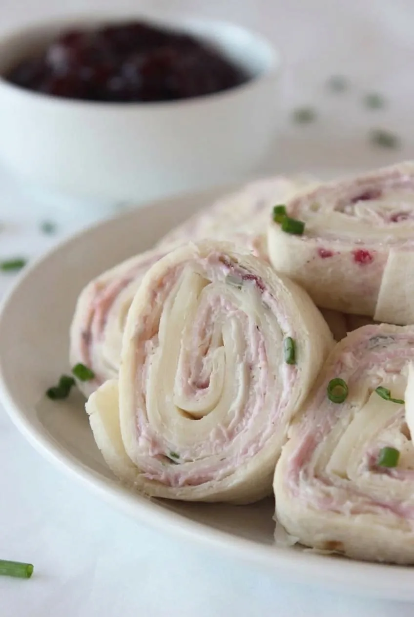 Close view of a turkey and cranberry pinwheel showing its creamy, tightly layered spiral