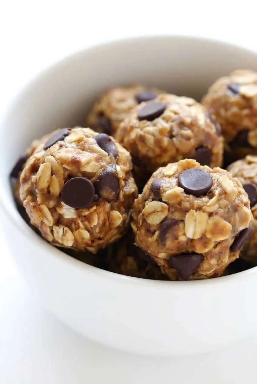 Close view of intact oat flakes and dark chocolate chips embedded in peanut butter oat energy balls