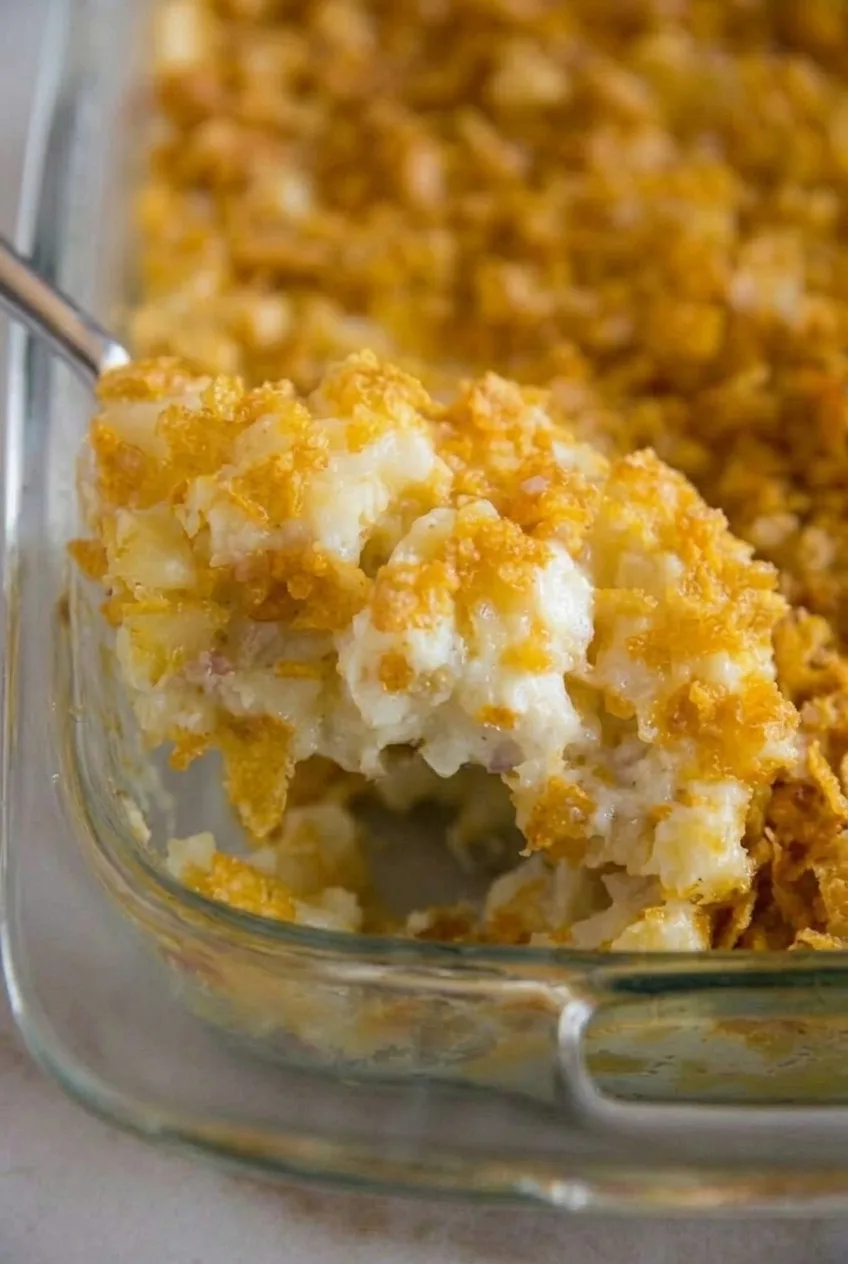 Close view of diced potatoes in thick, creamy filling beneath coarse golden cornflakes