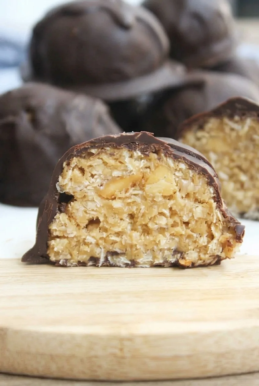 Close view of a chocolate peanut butter ball cross-section showing its flaky filling and chopped peanuts