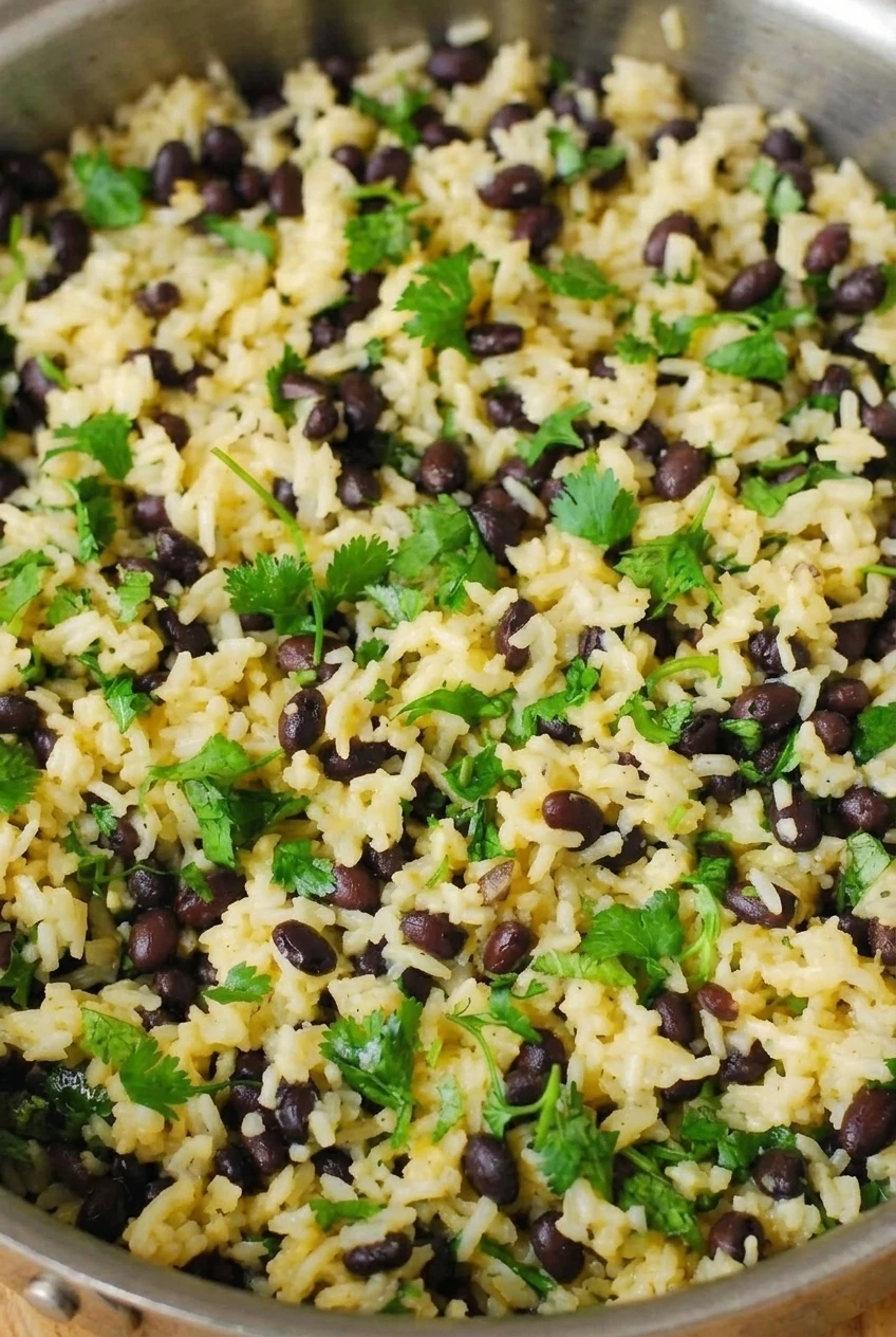 Close detail of distinct rice grains, whole black beans, and cilantro