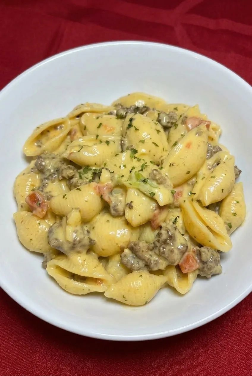 Full bowl of Crock Pot Rotel Pasta with beef, golden cheese sauce, and a light parsley garnish