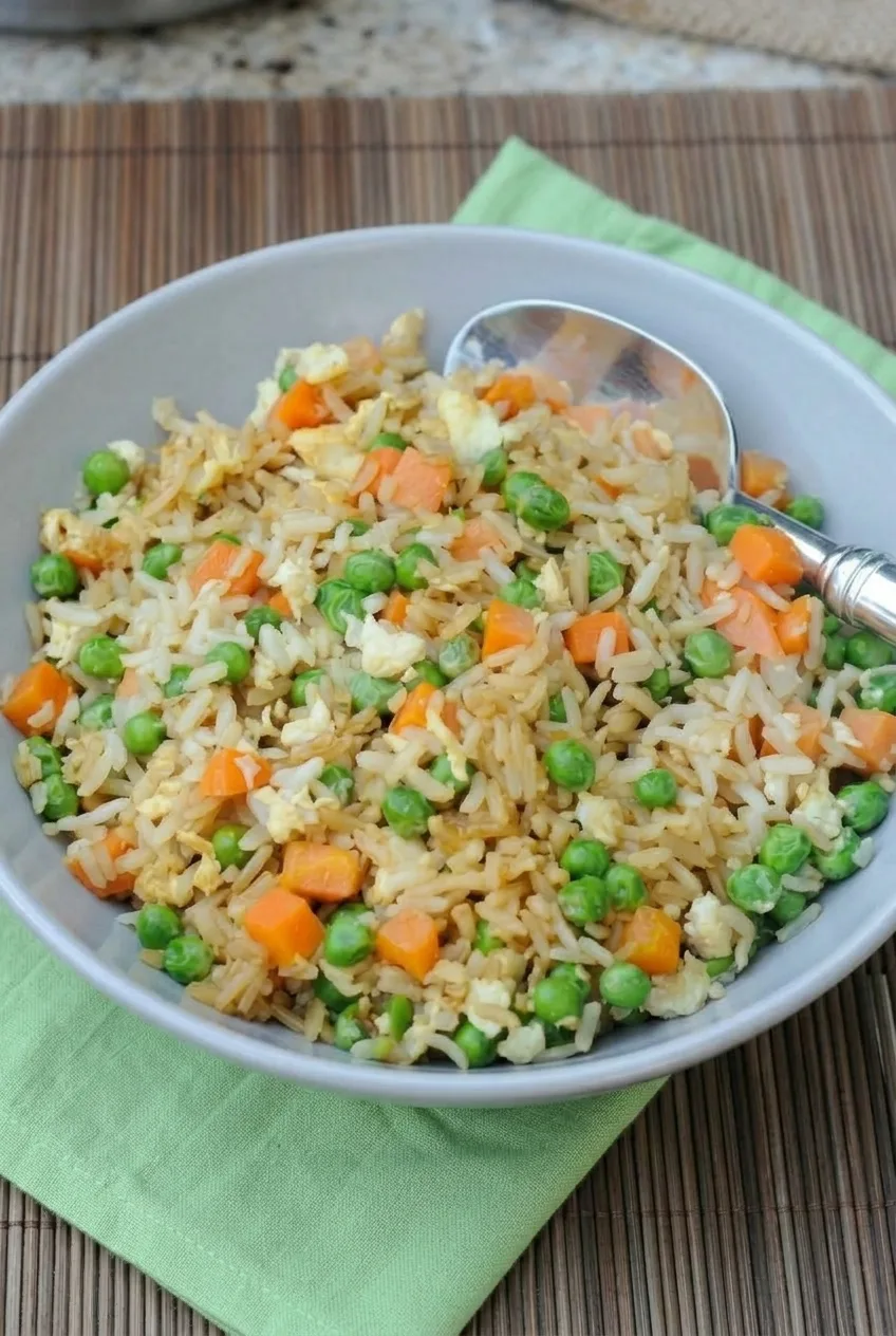 Complete bowl of chicken fried rice on a green cloth over a wooden table