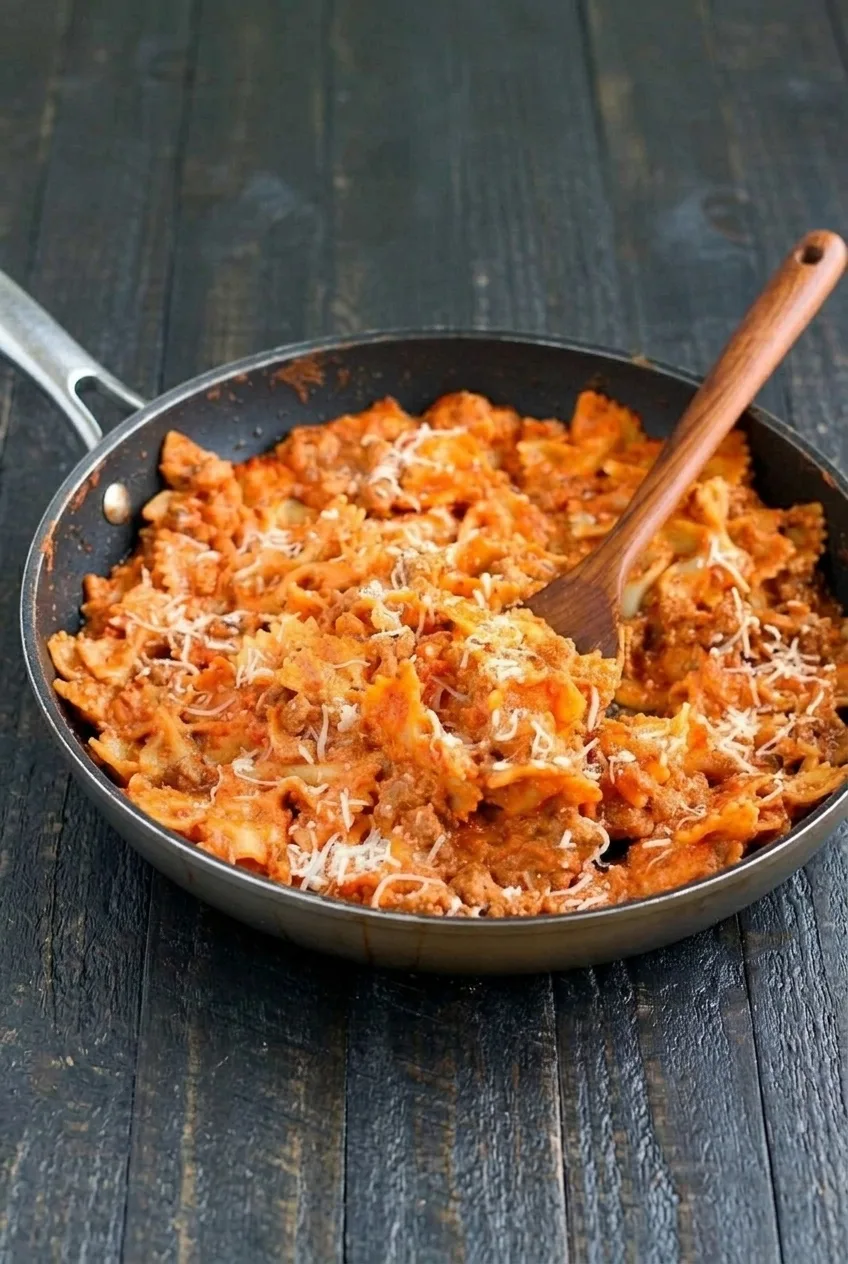 Wide view of the complete bowtie pasta lasagna skillet with farfalle, beef, and Parmesan