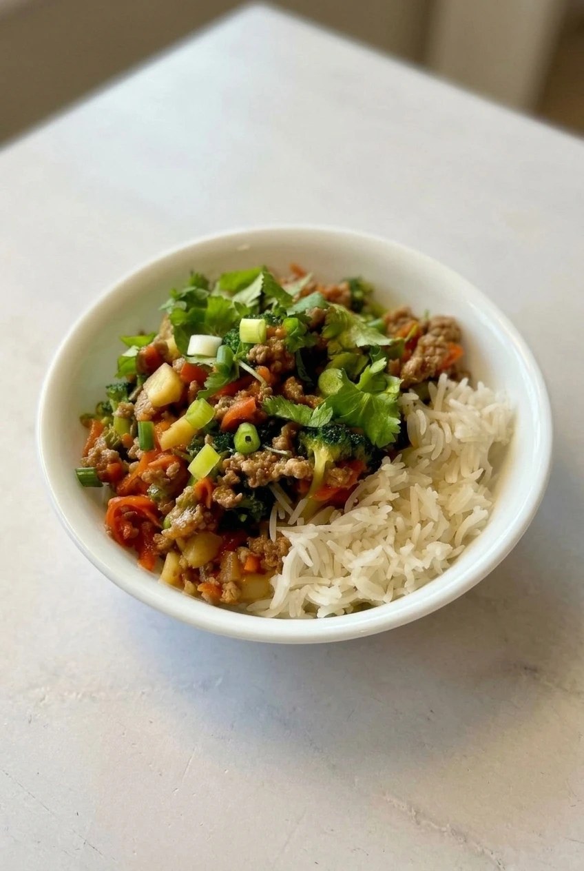 A complete ground turkey teriyaki rice bowl centered on a light tabletop, with rice and turkey mixture kept separate