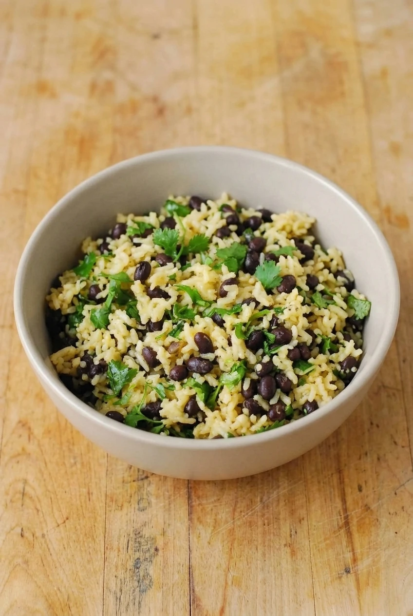 A bowl of cilantro-studded rice and black beans, shown with the full serving visible